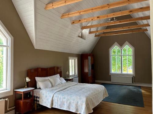 a bedroom with a large bed and two windows at Tornvillan in Mariehamn
