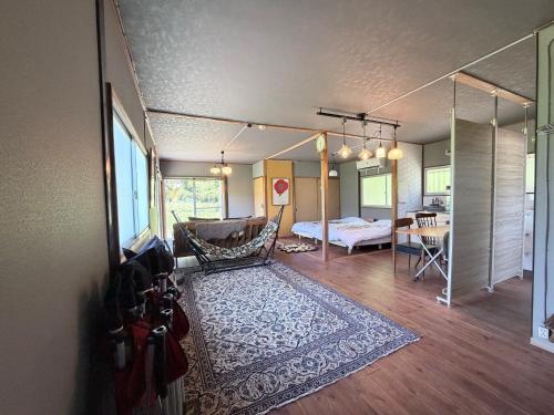 a living room with a bed and a table at KUMANOYASAI BASE in Chikatsuyu in Chikatsuyu