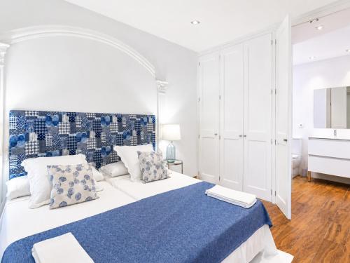 a white bedroom with a blue and white bed at Villa Bruno in El Toro