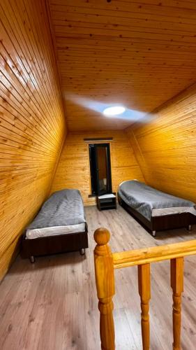 two beds in a room with a wooden ceiling at Kolsai Satu in Saty