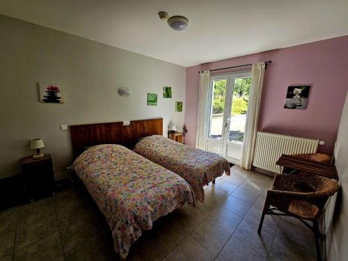 a bedroom with two beds and a window at Gite des Monges in Authon