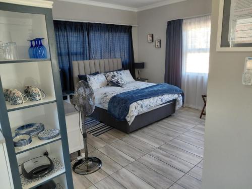 a bedroom with a bed with a fan and a window at Naomi's Sky Loft Little Falls in Roodepoort