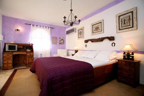 サンタ・エウラリア・デス・リウにあるCasa Albaの紫色のベッドルーム(ベッド1台、テレビ付)