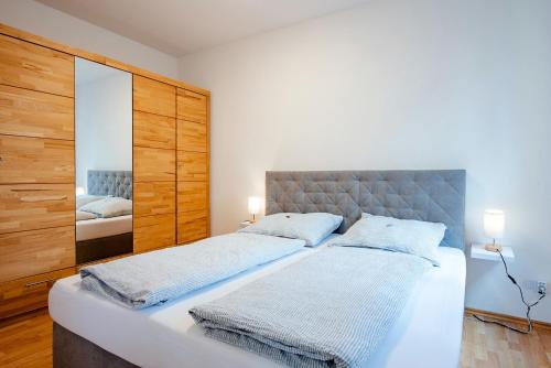 a bedroom with a large bed and a mirror at Plätzchen im Grünen in Owingen