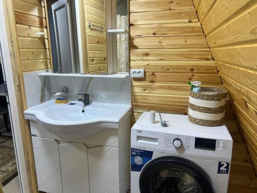 a bathroom with a sink and a washing machine at Esal Rest Zone in Tong