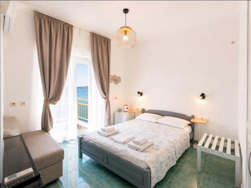 a bedroom with a bed and a large window at Hotel Prinos in Skala Prinou