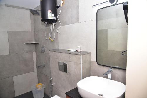 a bathroom with a toilet and a sink and a mirror at HOTEL THIRD EYE bY RAMANA TOWERS in Tiruvannāmalai