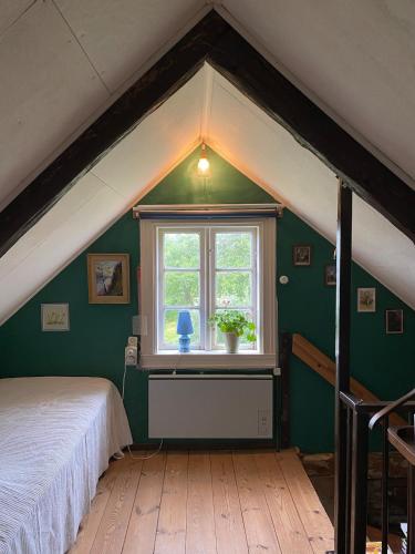 a bedroom with a white bed and a window at Sjöberg's Cosy Cottage in Ljungby