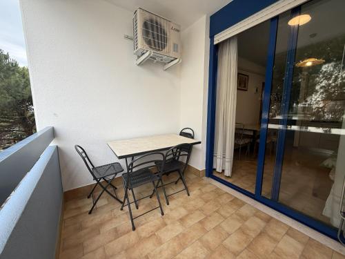 a balcony with a table and chairs and a fan at Condominio Vera Cruz in Bibione