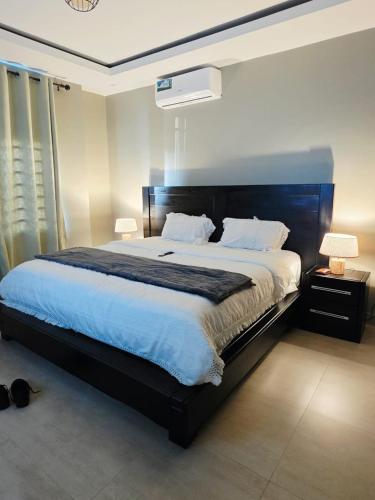 a bedroom with a large bed and two lamps at Ednomis Apartment in Mazabuka