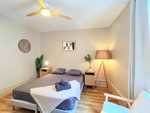 a bedroom with a bed and a ceiling fan at L'instant à Foix - Authentique & Chaleureux in Foix
