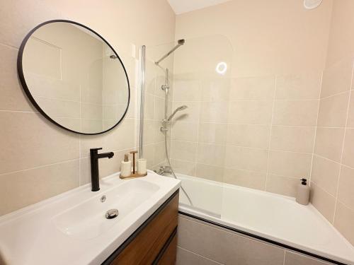 a bathroom with a sink and a mirror and a tub at L'instant à Foix - Authentique & Chaleureux in Foix