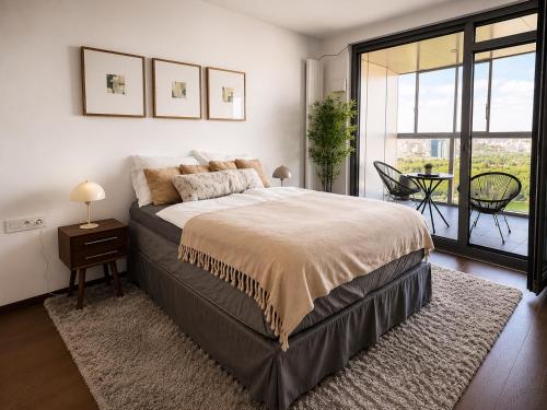 a bedroom with a large bed and a balcony at New Eurovea Tower in Bratislava
