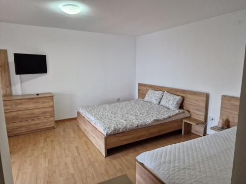 a bedroom with a bed and a tv on the wall at Casa Rodica Turda in Turda