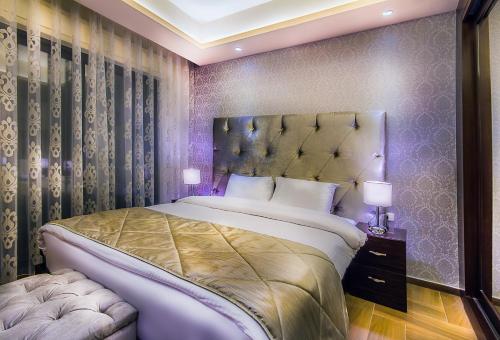 a bedroom with a large bed and two lamps at Nadine Hotel Suites in Amman