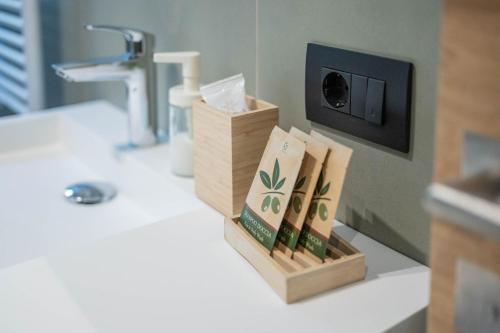 a bathroom counter with a sink with a box of books at Alpen Suite Apartment in San Vigilio Di Marebbe