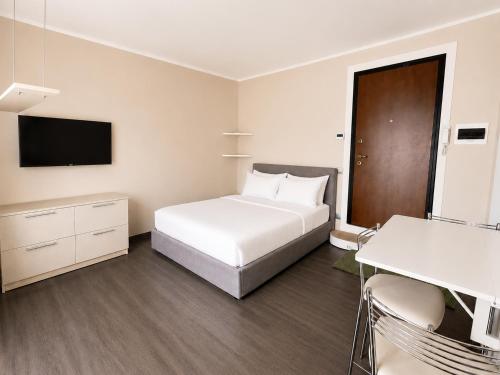 a hotel room with a white bed and a television at Porta Nuova Studio - Sostify in Bergamo
