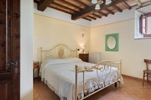 a bedroom with a white bed and a wooden ceiling at Casolare Sotto le Mura in Anghiari