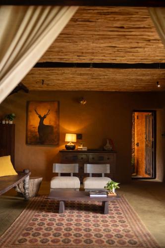 a bedroom with two beds in a room with a ceiling at The Mudhouse Marayoor in Munnar