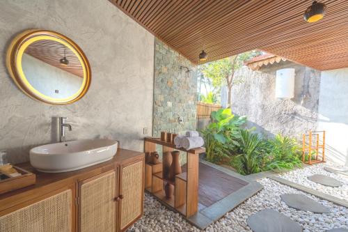 a bathroom with a sink and a mirror at Bi Bi Bliss Ubud Villa in Ubud