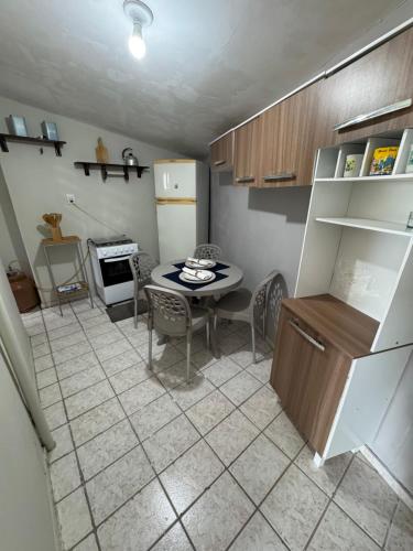 a kitchen with a table and a small table and a kitchen with a refrigerator at Cantinho Muriu in Ceará-Mirim