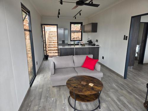 a living room with a couch and a table at Lazy Hill Eco Lodge in Warmbaths