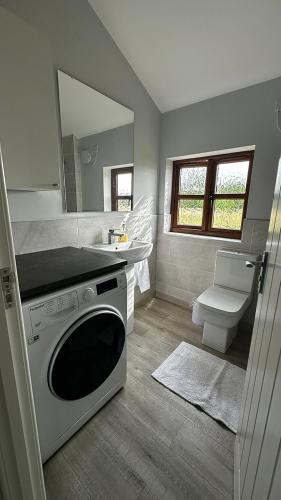 a bathroom with a sink and a washing machine at Peacock Barn in Walsoken