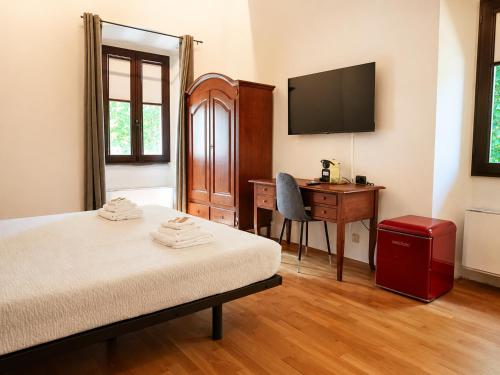 a bedroom with a bed and a desk and a television at Antico Monastero del Lavello in Calolziocorte