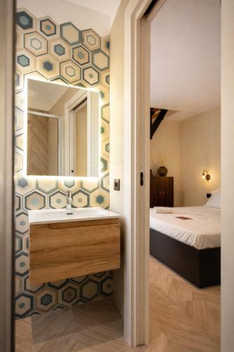 a bathroom with a sink and a bed and a mirror at L'ateneo Lumiére in Agrigento