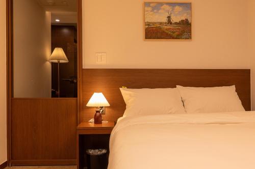 a bedroom with a large bed and a mirror at LUVO Signature Hotel in Seoul