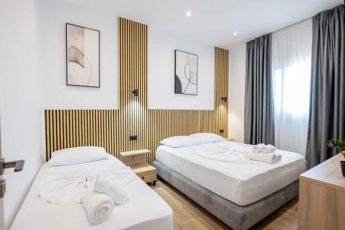 two beds in a hotel room with white sheets at Ionian View Rooms in Himare