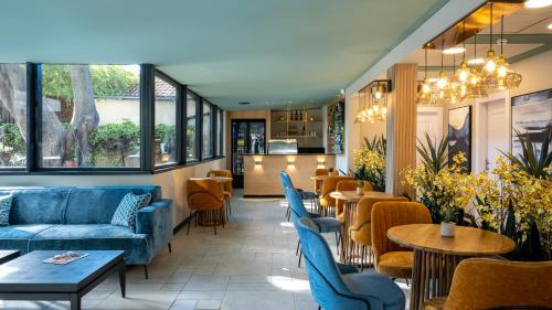 a restaurant with blue couches and tables and chairs at Jacob Ohalo Kinneret in Kinneret