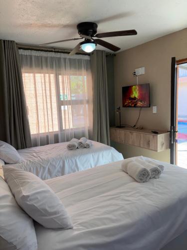 a bedroom with two beds and a ceiling fan at Urban Rest Guesthouse in Mahikeng