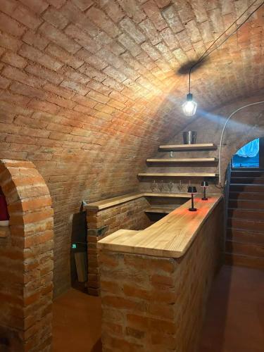 a brick walled kitchen with a counter and stairs at Apartmán Sebina s vinným sklípkem in Drnholec