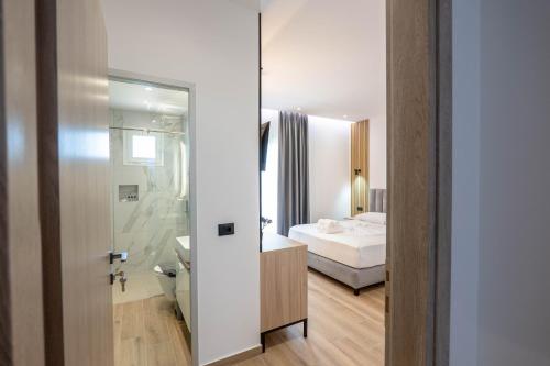 a bedroom with a bed and a bathroom with a mirror at Ionian View Rooms in Himare