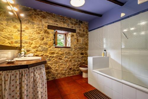 a bathroom with a sink and a tub and a toilet at La Casa de Torre in Ribadesella