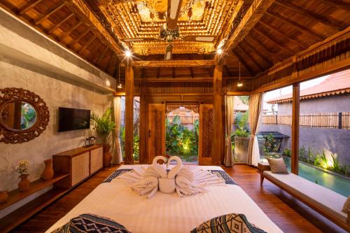 a bedroom with two swans sitting on a bed at Bi Bi Bliss Ubud Villa in Ubud