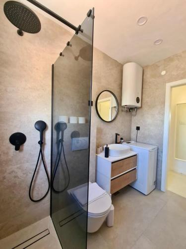 a bathroom with a shower and a toilet and a sink at PHOS - Pag Residences in Kustići