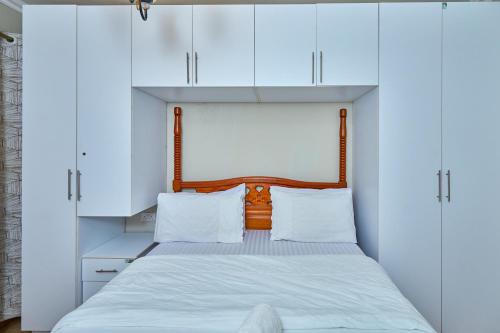 a bedroom with white cabinets and a bed at 4 Bedroom Apartment Near JKIA & SGR in Nairobi