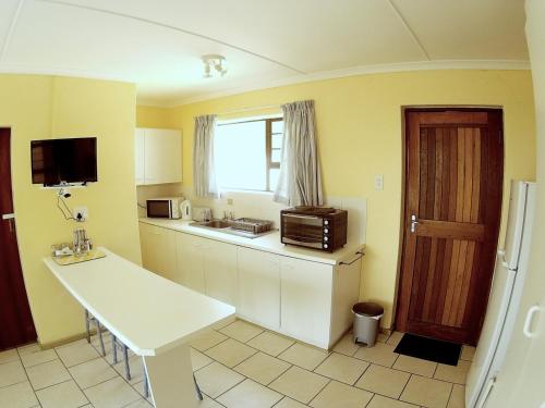 a kitchen with a counter and a sink and a refrigerator at Sandown Self-Catering in Cape St Francis