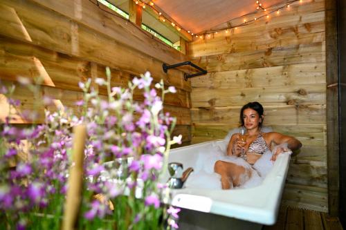a woman sitting in a bath tub with a dog at Bird Box in Carlisle