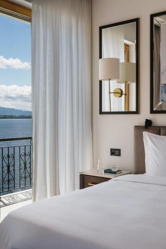 a bedroom with a bed and a view of the ocean at Beau-Rivage Nyon in Nyon