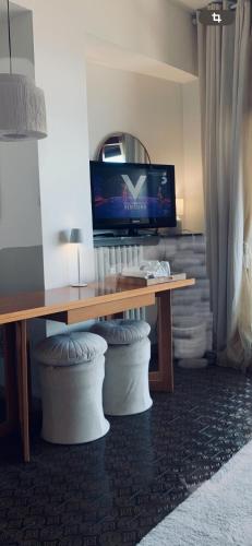 a living room with a wooden table and a television at Suite bijoux On Lake Maggiore in Verbania