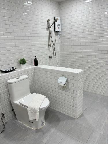 a white bathroom with a toilet and a bath tub at The See Stay Hatyai in Hat Yai