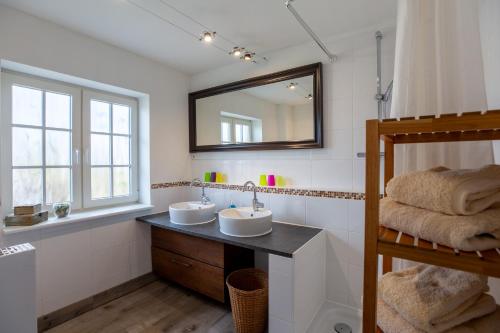 a bathroom with two sinks and a mirror at Haus am Leuchtturm ,,Austernfischer Haus " in Pellworm