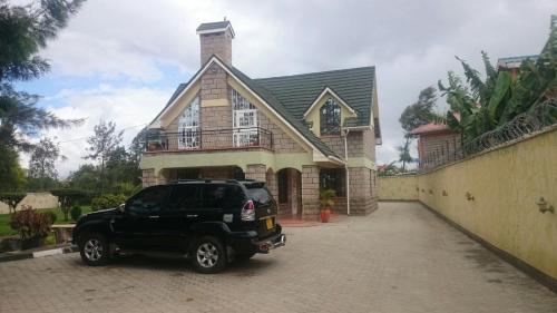 a black suv parked in front of a house at Mutabari's Home in Kitengela 