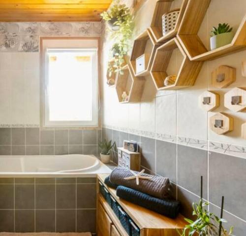 a bathroom with a tub and a window and a bath tub at Villa L'Epicléa, Chorges, entre lac et montagnes in Chorges