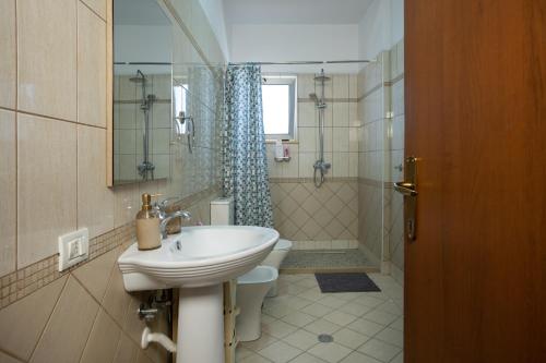 a bathroom with a sink and a toilet and a shower at Fole Maison in Durrës