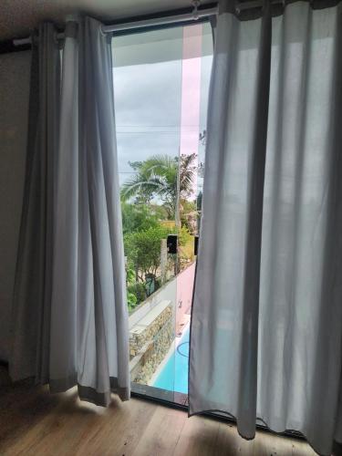 a window with a view of a swimming pool at Casa Casal Itapoá in Itapoa