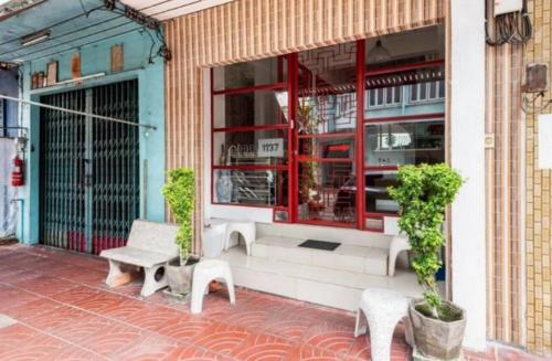 a store front with two benches and a window at 1137 Hostel in Bangkok